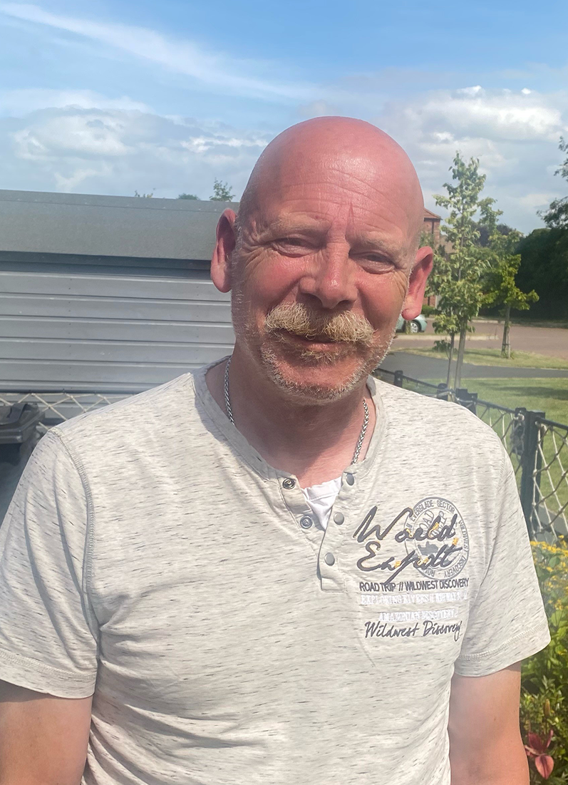 Veteran Nigel Unsworth stood in his back garden, smiling and looking directly at the camera